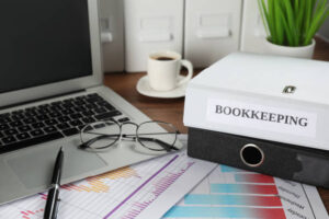 Folders, laptop and documents on desk in office. Bookkeeper’s workplace