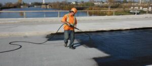 Worker applying waterproof coating on a terrace surface for home protection