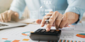 Personal tax calculation with calculator, financial reports and digital tax documents.